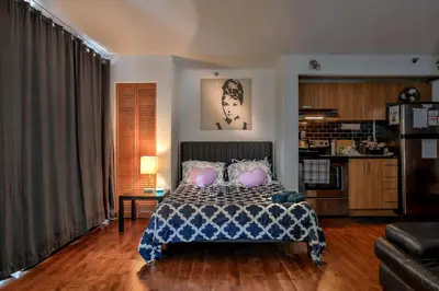 a bedroom with a bed with pillows and a couch at Beautiful APARTMENT - GORGEOUS VIEW of the city - 7 MINUTE WALK TO METRO - SELF CHECK IN in Montréal