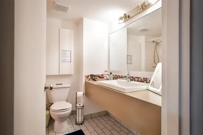 a white bathroom with a toilet and a sink at Beautiful APARTMENT - GORGEOUS VIEW of the city - 7 MINUTE WALK TO METRO - SELF CHECK IN in Montréal