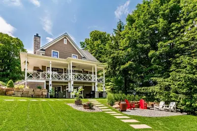 a large white house with a yard with green grass at Escale ski & Spa en Estrie in Shefford