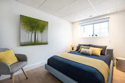 a bedroom with a bed and a chair at Escale ski & Spa en Estrie in Shefford