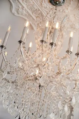 a white chandelier with candles on a ceiling at Villa Dante By Denstays in Montréal