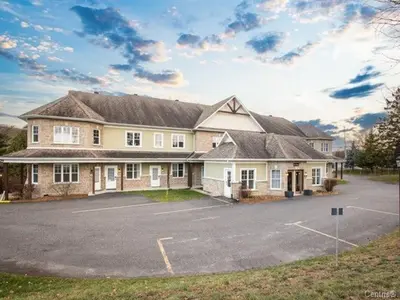 a large house with a parking lot in front of it at Condo-hôtel Le Champlain - Condo103 Bromont in Bromont