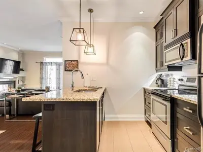 a large kitchen with a large island in the middle at Condo-hôtel Le Champlain - Condo103 Bromont in Bromont