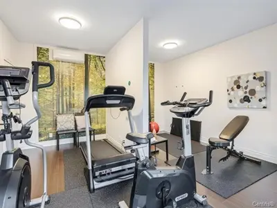 a gym with several exercise equipment in a room at Condo-hôtel Le Champlain - Condo103 Bromont in Bromont