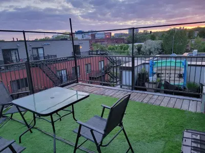 a patio with a table and chairs on a balcony at Sunset Apartment in Montréal