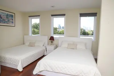 two beds in a room with two windows at Sunset Apartment in Montréal