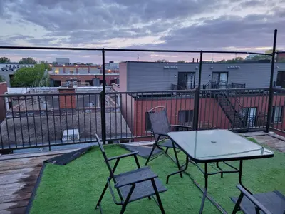 a patio with a table and chairs on a balcony at Sunset Apartment in Montréal