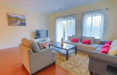 a living room with two couches and a tv at Sunset Apartment in Montréal