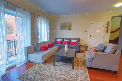 a living room with a couch and two chairs and a table at Sunset Apartment in Montréal