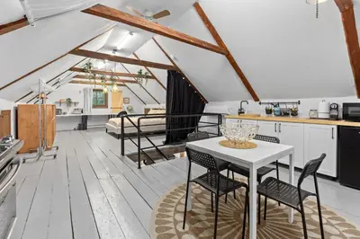 a kitchen and living room with a table and chairs at L'Artisan - Vieux-Terrebonne in Terrebonne