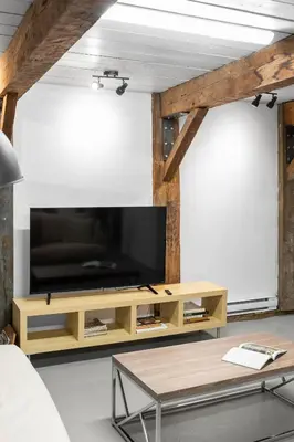 a living room with a flat screen tv on a wall at L'Artisan - Vieux-Terrebonne in Terrebonne