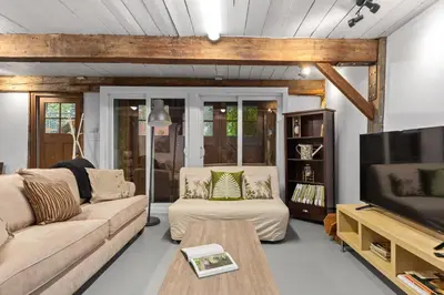 a living room with a couch and a tv at L'Artisan - Vieux-Terrebonne in Terrebonne