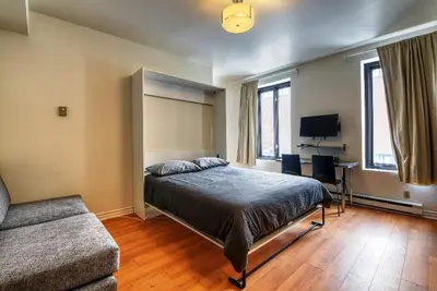 a bedroom with a bed and a desk and a couch at Studio Stays Downtown Montreal in Montréal