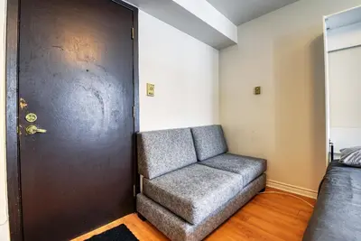a couch sitting in a room next to a door at Studio Stays Downtown Montreal in Montréal