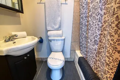 a bathroom with a toilet and a sink and a shower curtain at Studio Stays Downtown Montreal in Montréal