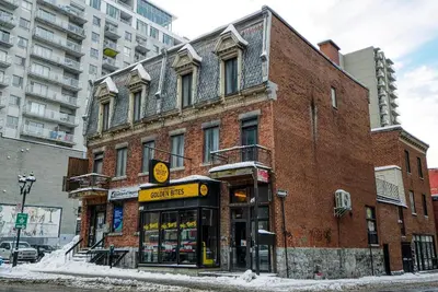 a brick building on a city street with a store at Studio Stays Downtown Montreal in Montréal