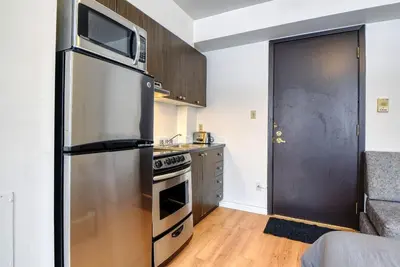 a kitchen with a stainless steel refrigerator and a stove at Studio Stays Downtown Montreal in Montréal
