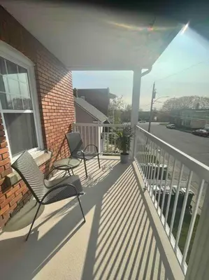 a porch with two chairs and a window and a building at Le paisible ensoleillé ! beau 51/2 à Drummondville in Drummondville