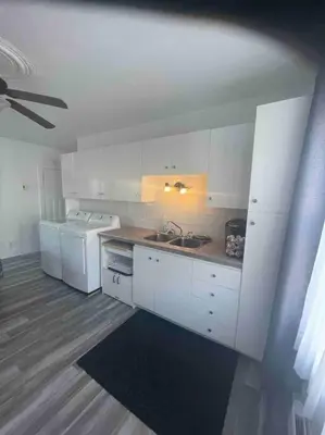 a kitchen with white cabinets and a sink at Le paisible ensoleillé ! beau 51/2 à Drummondville in Drummondville
