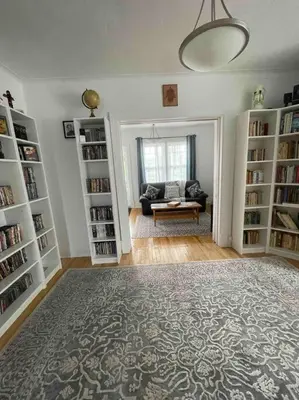 a living room with book shelves and a rug at Le paisible ensoleillé ! beau 51/2 à Drummondville in Drummondville
