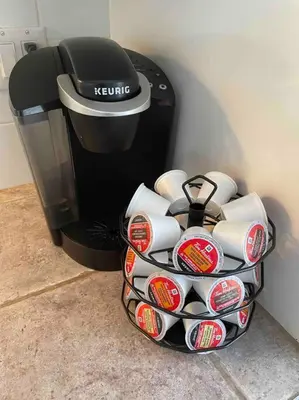 a basket of cups sitting next to a coffee maker at Le paisible ensoleillé ! beau 51/2 à Drummondville in Drummondville