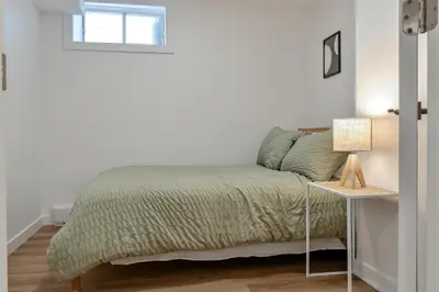 a bedroom with a bed and a table with a lamp at Le Eleven 55 - Billard - 5 lits in Trois-Rivières