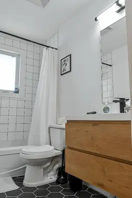 a bathroom with a toilet and a sink and a mirror at Le Eleven 55 - Billard - 5 lits in Trois-Rivières