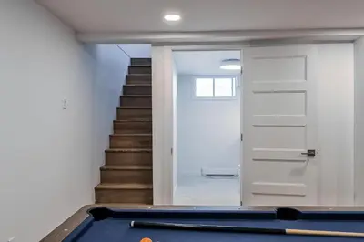 a room with a pool table and a staircase at Le Eleven 55 - Billard - 5 lits in Trois-Rivières