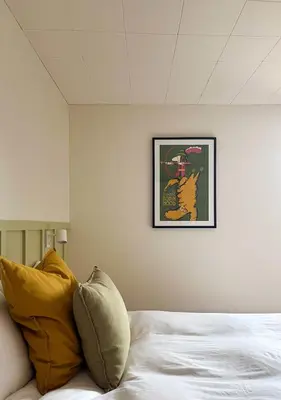 a bed with a picture of a cat on the wall at Chez Léo par Maison Dudley in Lac-Mégantic