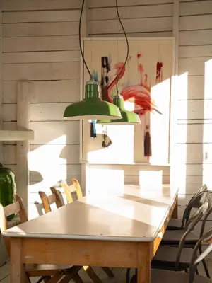a wooden table with chairs and two green lamps at Chez Léo par Maison Dudley in Lac-Mégantic