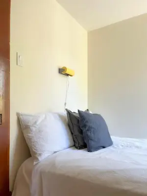 a bed with two pillows and a lamp on it at Chez Léo par Maison Dudley in Lac-Mégantic