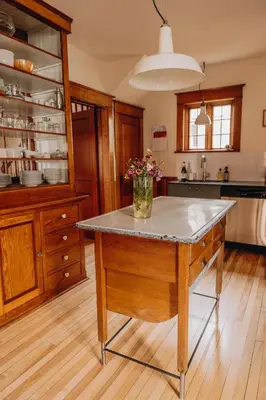 a kitchen with a table with a vase of flowers on it at Chez Léo par Maison Dudley in Lac-Mégantic