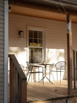a patio with a table and chairs on a porch at Le Central par Maison Dudley in Lac-Mégantic