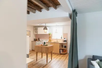 a kitchen with a table in the middle of a room at Le Loft par Maison Dudley in Lac-Mégantic