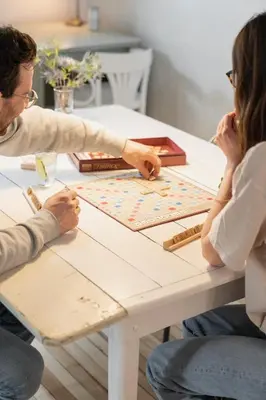 two people sitting at a table playing a board game at Le Loft par Maison Dudley in Lac-Mégantic