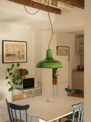 a green pendant light hanging over a dining room table at Le Loft par Maison Dudley in Lac-Mégantic