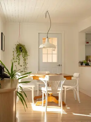a white dining room with a table and chairs at Le Boulevard par Maison Dudley in Lac-Mégantic