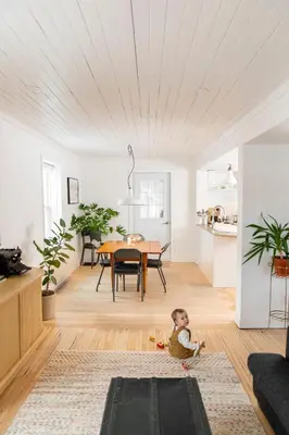 a baby sitting on the floor in a living room at Le Boulevard par Maison Dudley in Lac-Mégantic