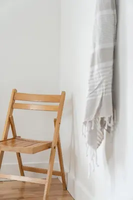 a wooden chair sitting in front of a wall at Le Boulevard par Maison Dudley in Lac-Mégantic