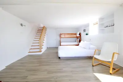 a bedroom with a bed and a stair case at Le Vacancier sur le lac in Saint Denis de Brompton