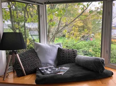 a couch sitting in front of a large window at Le Vacancier sur le lac in Saint Denis de Brompton