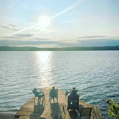 a group of chairs sitting on a dock near the water at Le Vacancier sur le lac in Saint Denis de Brompton