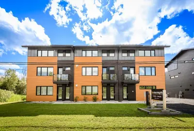 an exterior view of a building at Le Memph Hirondelle spacious comfortable condo cottage eco responsible 3 bedrooms - hot tub & pool Memphrémagog Lake in Magog-Orford