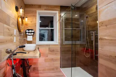 a bathroom with a shower and a red bike in it at Chalet Memphrémagog Ski Spa, Étang in Mansonville