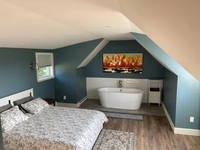 a bedroom with a bed and a bath tub at Relaxez, condo Zen, climatisé, campagne&lacs in Magog-Orford
