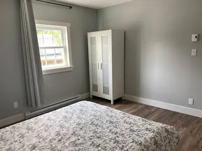 an empty bedroom with a bed and a window at Relaxez, condo Zen, climatisé, campagne&lacs in Magog-Orford