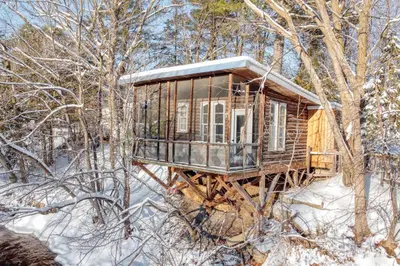 a tree house in the woods in the snow at Le Perché-sur-la-rivière in Joliette