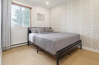 a bedroom with a bed and a window at Top Rated Vacation House Montreal Private Parking in Laval