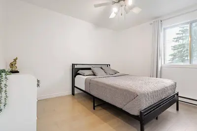 a bedroom with a bed and a ceiling fan at Top Rated Vacation House Montreal Private Parking in Laval