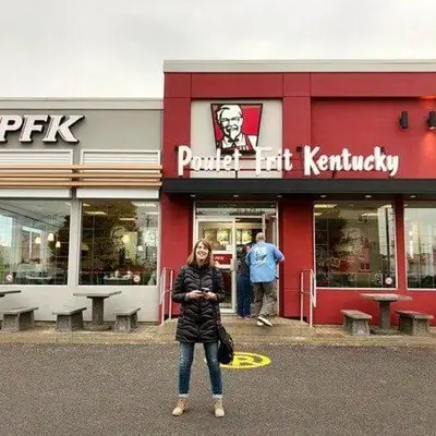 a woman is standing in front of a store at Confort in Montréal